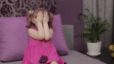Küçük çocuk televizyon izlerken oturuyor. Korkak kız korku filmi izliyor.