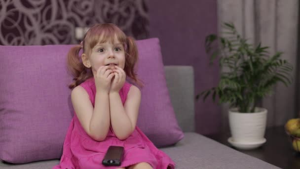 Petit enfant assis en regardant la télévision. Enfant effrayé fille regarder film d'horreur — Video