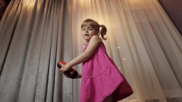 ワイヤレススピーカーを持つ子供の女の子は音楽を聴く。自宅で踊る — ストック動画