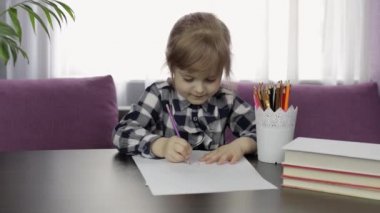 Evde kalemle resim çizen sevimli bir kız çocuğu. Uzaklık eğitimi