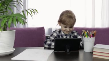 Dijital tablet bilgisayar kullanarak online ödev okuyan bir kız. Uzaklık eğitimi