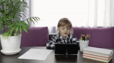 Dijital tablet bilgisayar kullanarak online ödev yapan bir kız. Uzaklık eğitimi
