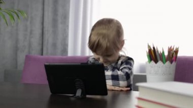 Dijital tablet bilgisayar kullanan kız çevrimiçi dersler öğreniyor. Uzaklık eğitimi