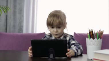 Dijital tablet bilgisayar kullanan kız çevrimiçi dersler öğreniyor. Uzaklık eğitimi