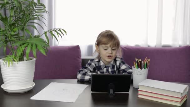 Menina fazendo lição de casa on-line usando computador tablet digital. Ensino à distância — Vídeo de Stock