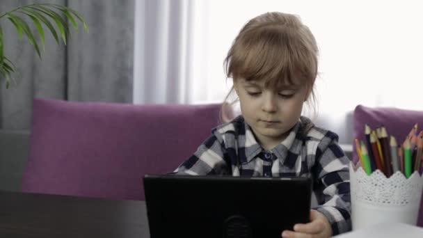 Meisje doet thuis lessen met een digitale tablet computer. Afstandsonderwijs — Stockvideo