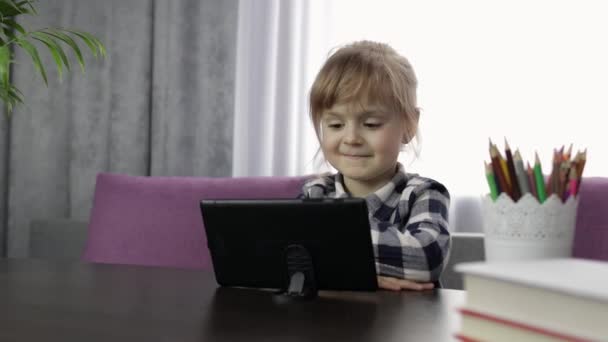 Dijital tablet bilgisayar kullanarak online ders alan bir kız. Uzaklık eğitimi — Stok video