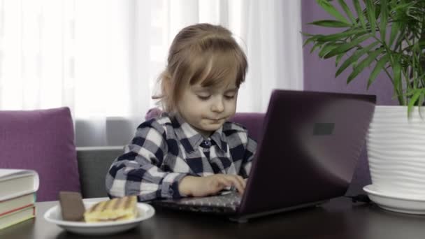 Chica aprendiendo lecciones en línea utilizando el ordenador portátil digital. Educación a distancia — Vídeos de Stock