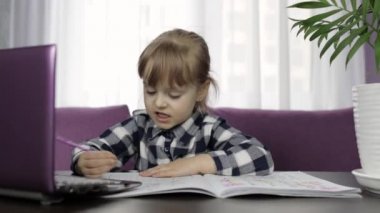 Dijital dizüstü bilgisayar kullanarak online ödev yapan bir kız. Uzaklık eğitimi