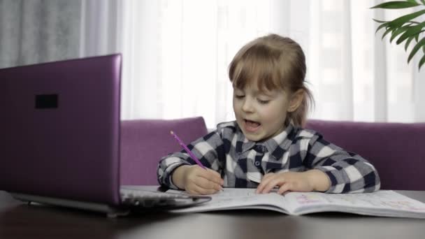 Dijital dizüstü bilgisayar kullanarak online ödev okuyan bir kız. Uzaklık eğitimi — Stok video