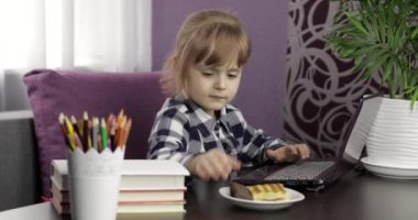 Dijital dizüstü bilgisayar kullanarak online ders alan bir kız. Uzaklık eğitimi