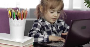 Dijital dizüstü bilgisayar kullanarak online ödev okuyan bir kız. Uzaklık eğitimi