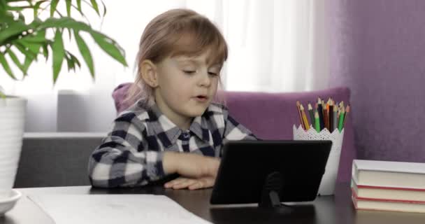 Chica haciendo tareas en línea utilizando tableta digital. Educación a distancia — Vídeo de stock