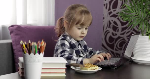 Menina fazendo lição de casa on-line usando computador portátil digital. Ensino à distância — Vídeo de Stock