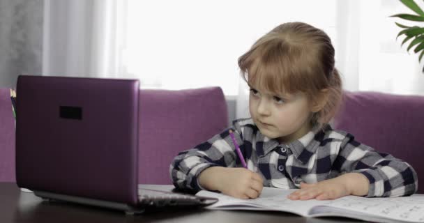 Dijital dizüstü bilgisayar kullanarak online ödev okuyan bir kız. Uzaklık eğitimi — Stok video