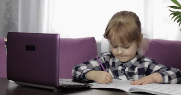 Menina fazendo lição de casa on-line usando computador portátil digital. Ensino à distância — Vídeo de Stock