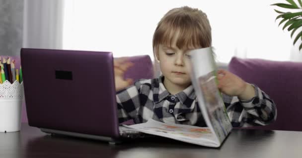 Дівчина вивчає домашнє завдання онлайн за допомогою цифрового комп'ютера для ноутбуків. Дистанційне навчання — стокове відео