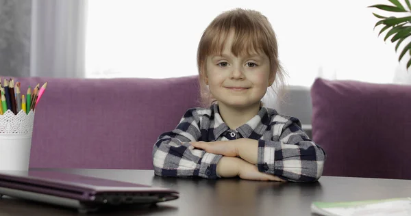 Девушка сидит на столе дома. Изучаю домашнее задание онлайн. Дистанционное образование — стоковое фото