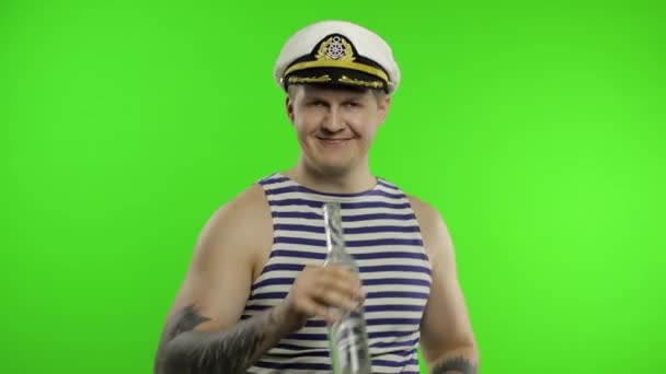 Námořník chodí, pije vodku z láhve. Námořník v námořnické vestě. — Stock video