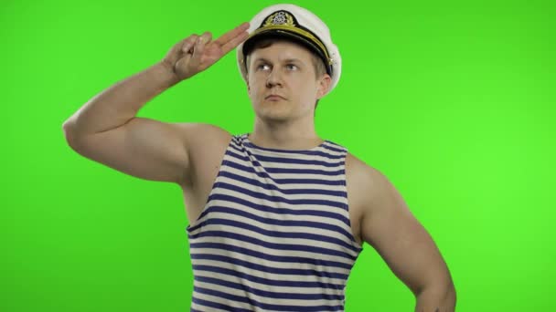 Young sailor man salutes with hand, looking up. Seaman guy in sailors vest — Stock Video