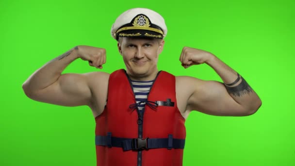 Mladý svalnatý námořník pracuje jako plavčík na pláži ukazuje svaly. Klíč Chroma — Stock video