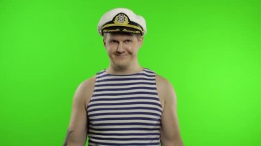 Denizci halterle ağırlık kaldırıyor. Denizci yeleği giyen denizci.