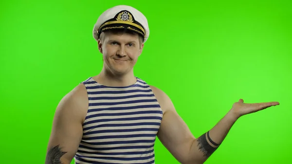 Young sailor man pointing to something with hands. Seaman guy in sailors vest — Stock Photo, Image