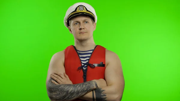 Young muscular sailor man works as lifeguard at beach observe the territory