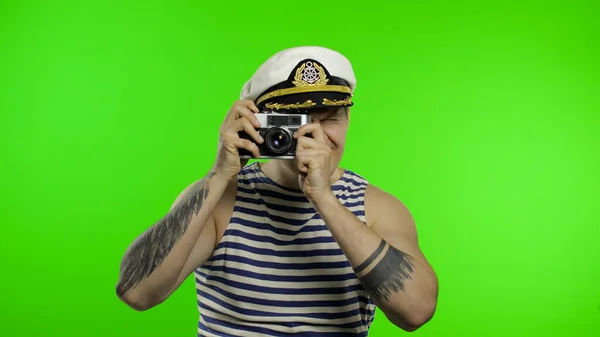Jovem marinheiro tira uma foto em uma câmera retro. Marinheiro em colete de marinheiros — Fotografia de Stock