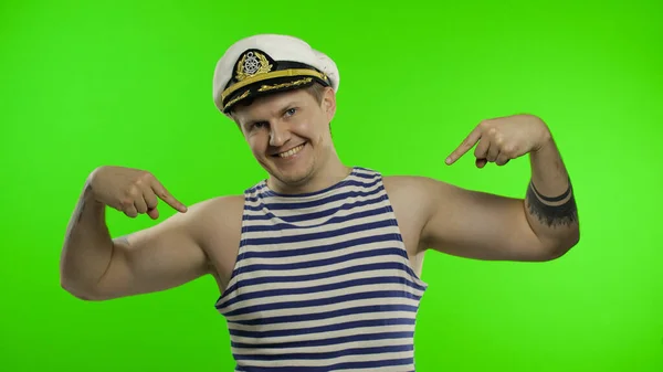 Een jonge zeeman die zich met zijn vingers trots en gelukkig aanwijst. Zeeman. — Stockfoto