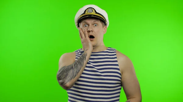 Young sailor man expresses shock, looks surprised. Seaman guy in sailors vest