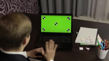 Erkek öğretmen bilgisayarda video görüşmesi yapıyor. Yeşil ekran. Uzaklık eğitimi