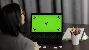 Çevrimiçi uzaklık eğitimi veren kadın öğretmen yeşil ekranda video çağrısı yapıyor