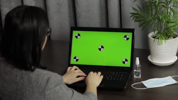 Woman are typing on laptop keyboard with green screen, chroma key. Distance work — Stock Video