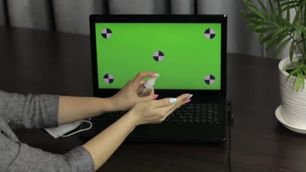 Las manos de las mujeres utilizan desinfectante cerca de la computadora portátil con pantalla verde. Coronavirus — Vídeos de Stock