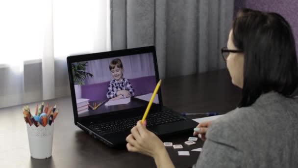 Vrouw leraar maakt videogesprek op laptop met weinig leerling. Afstandsonderwijs — Stockvideo