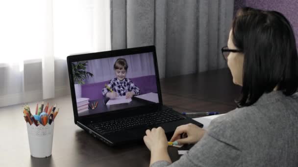 Vrouw leraar maakt videogesprek op laptop met kinderen leerling. Afstandsonderwijs — Stockvideo