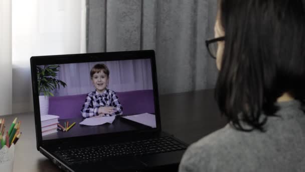 Nauczycielka wykonująca wideo rozmowę na laptopie z małym uczniem. Edukacja na odległość — Wideo stockowe