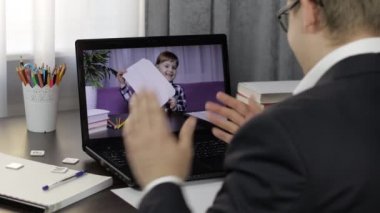 Erkek öğretmen bilgisayardan çocuklarla video görüşmesi yapıyor. Uzaklık eğitimi