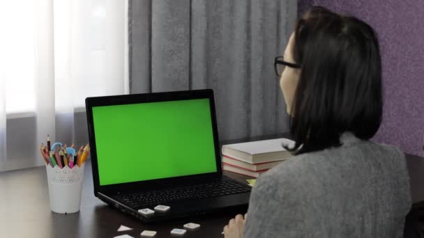 Insegnante donna che fa videochiamata online di istruzione a distanza sullo schermo verde del computer portatile — Video Stock