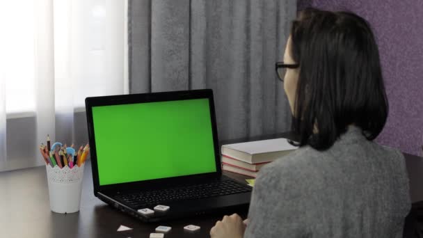 Vrouw leraar het maken van online afstandsonderwijs video oproep op laptop groen scherm — Stockvideo