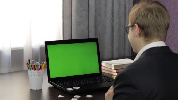 Een leraar die online videogesprekken voert op een laptop. Groen scherm. Afstandsonderwijs — Stockvideo