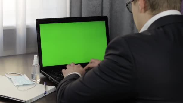 Homem tem videoconferência no laptop com tela verde. Trabalho à distância online — Vídeo de Stock