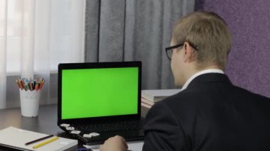 Erkek öğretmen bilgisayarda video görüşmesi yapıyor. Yeşil ekran. Uzaklık eğitimi