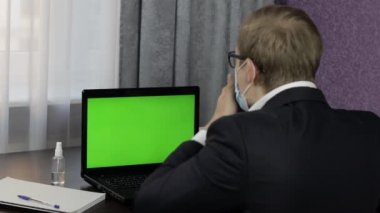 Adamın bilgisayarında yeşil ekranlı video konferansı var. Uzaklık çalışması çevrimiçi