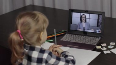 Evde dijital dizüstü bilgisayar kullanarak kadın öğretmenle kız kıza eğitim dersi.