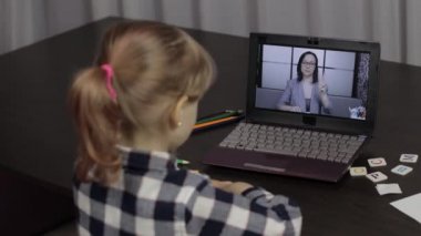 Evde dijital dizüstü bilgisayar kullanarak kadın öğretmenle kız kıza eğitim dersi.