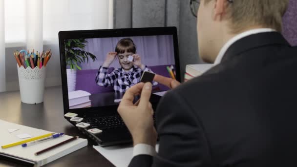 Insegnante di uomo che fa videochiamate sul computer portatile con un piccolo allievo. Istruzione a distanza — Video Stock