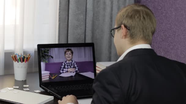 Professeur homme faisant appel vidéo sur ordinateur portable avec un petit élève. Enseignement à distance — Video