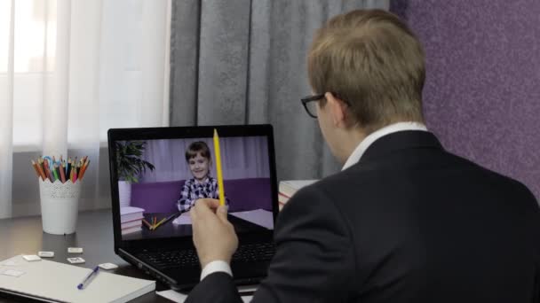 Man lärare gör videosamtal på laptop med liten elev. Distansutbildning — Stockvideo